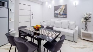 Un salón moderno con una mesa de comedor, sofá blanco y un cuadro en la pared.