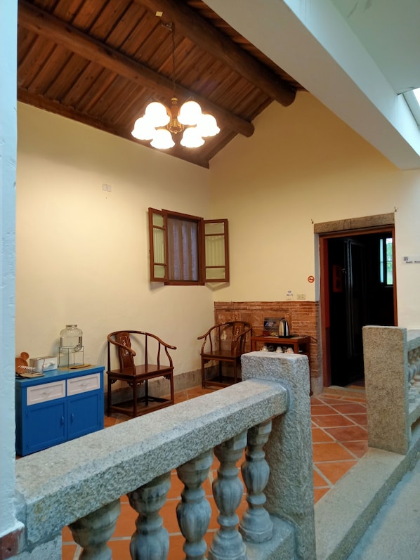 A room with a wooden ceiling, a stone bench, a blue cabinet, and a brick fireplace. - Artistic Nest (Jincheng)