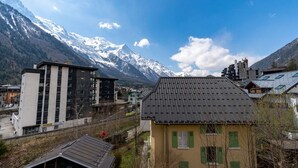 A mountain town with modern buildings, a prominent mountain range, and a clear sky.