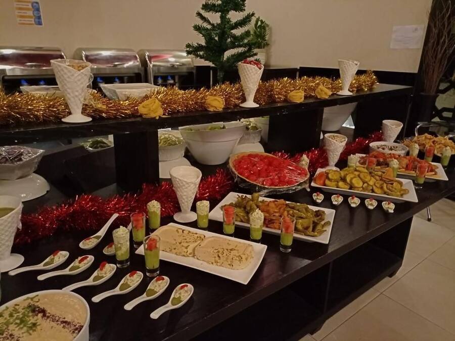 A buffet table with various food items and serving utensils.