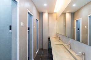 A modern bathroom with three sinks, a large mirror, and a tiled floor. - Momostay Capsule Hotel (George Town)