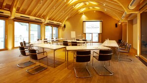 A conference room with a long table, multiple chairs, and a projector screen displaying "DAS LINDNER". - Romantik Hotel Das Lindner (Bad Aibling)