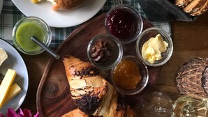 A variety of food items on a wooden table, including croissants, bread, and various dips. - Romantik Hotel Das Lindner (Bad Aibling)