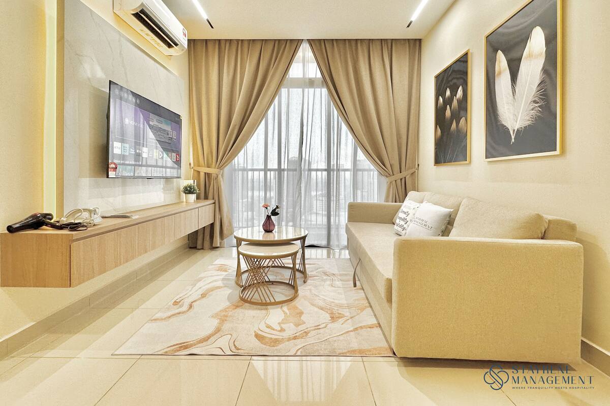 A modern living room with a beige sofa, a coffee table, and a TV mounted on the wall.