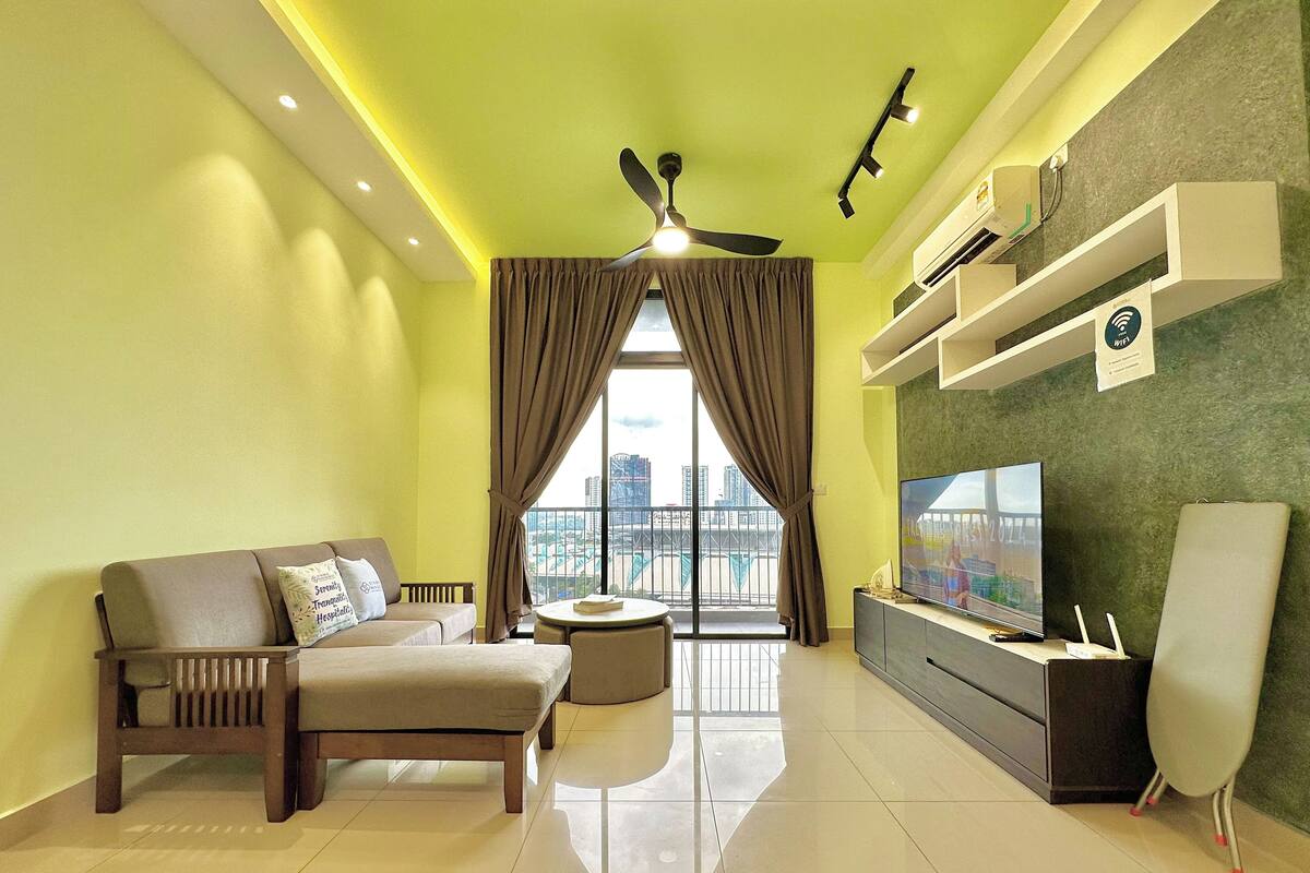 A modern living room with a sofa, a coffee table, a TV, and a ceiling fan.