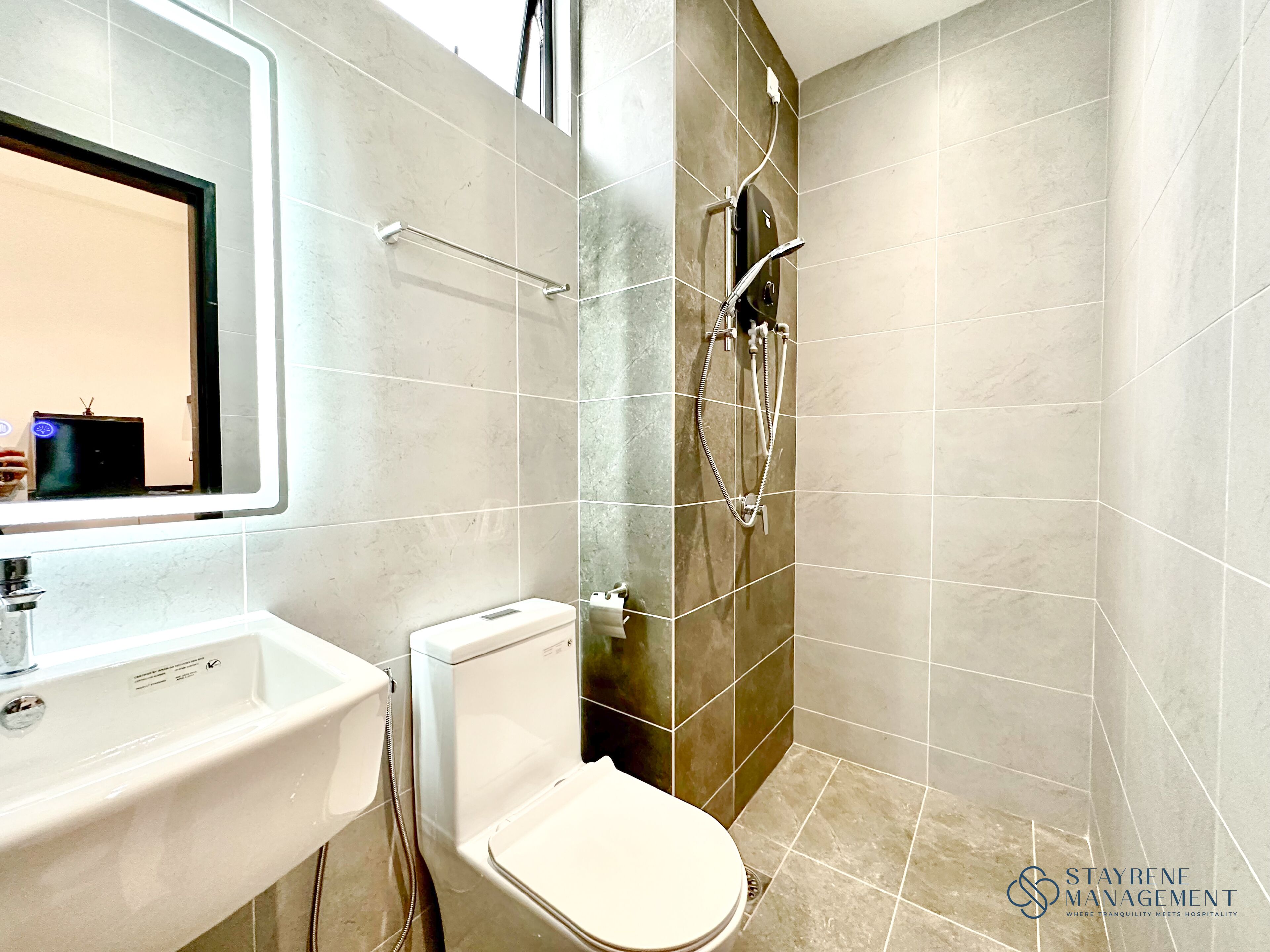 A modern bathroom with a toilet, sink, and shower.