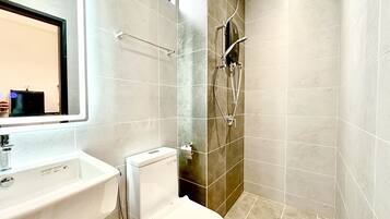 A modern bathroom with a toilet, sink, and shower.