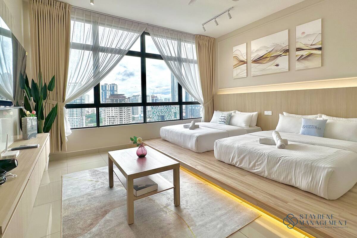 A modern hotel room with a large window, a bed, a sofa, a desk, and a ceiling fan.