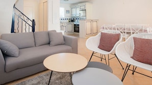 A modern living room with a sofa, two round tables, and white wicker chairs. - Esprit du Sud Vakantiehuis met 3 Slaapkamers, Mooi Uitzicht op Domaine du Golf (Roquebrune-sur-Argens)