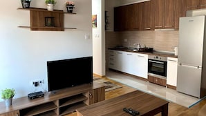 A modern kitchen with wooden cabinets, a built-in oven, and a stainless steel refrigerator. - Brand new 2 Bedroom Apartment in the Center Skopje (Skopje)