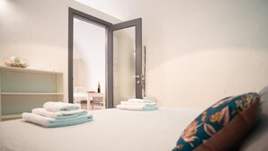 Ein Hotelzimmer mit Bett, Nachttisch, Stuhl und einer Tür zum Badezimmer.