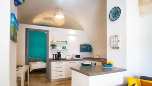 Eine moderne Küche mit weißen Schränken, einer zentralen Kochinsel und einem Essbereich mit Tisch und Stühlen.