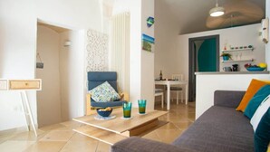 Ein modernes Wohnzimmer mit Sofa, Couchtisch und Essbereich.