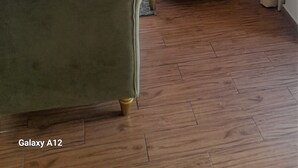 Un salón espacioso con un sofá grande, un sillón a juego y un otomano tapizado.