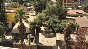 Zona residencial con diversos edificios, incluyendo un rascacielos en construcción, rodeada de árboles y vegetación.