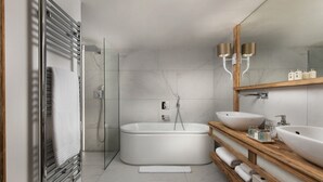 Ein modernes Badezimmer mit einer freistehenden Badewanne, einem großen Spiegel und einem hölzernen Waschtisch mit zwei Becken.