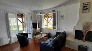 A living room with a sofa, a coffee table, and a TV.