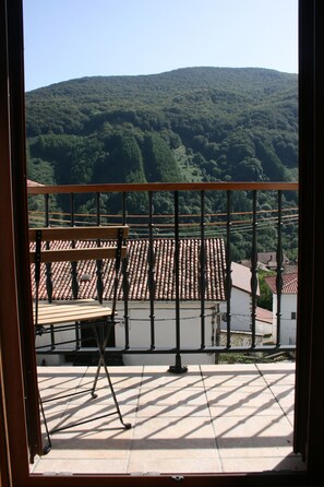 Un balcon donnant sur une colline.