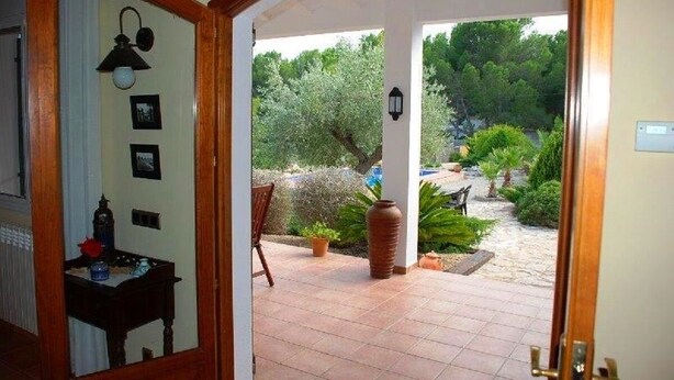 An interior doorway leading to a covered outdoor patio with a tiled floor, a wooden chair, and a large vase. - SAONA VILLAS (VN SILKA): villa 6 people, private pool, wifi (L'Ametlla de Mar)