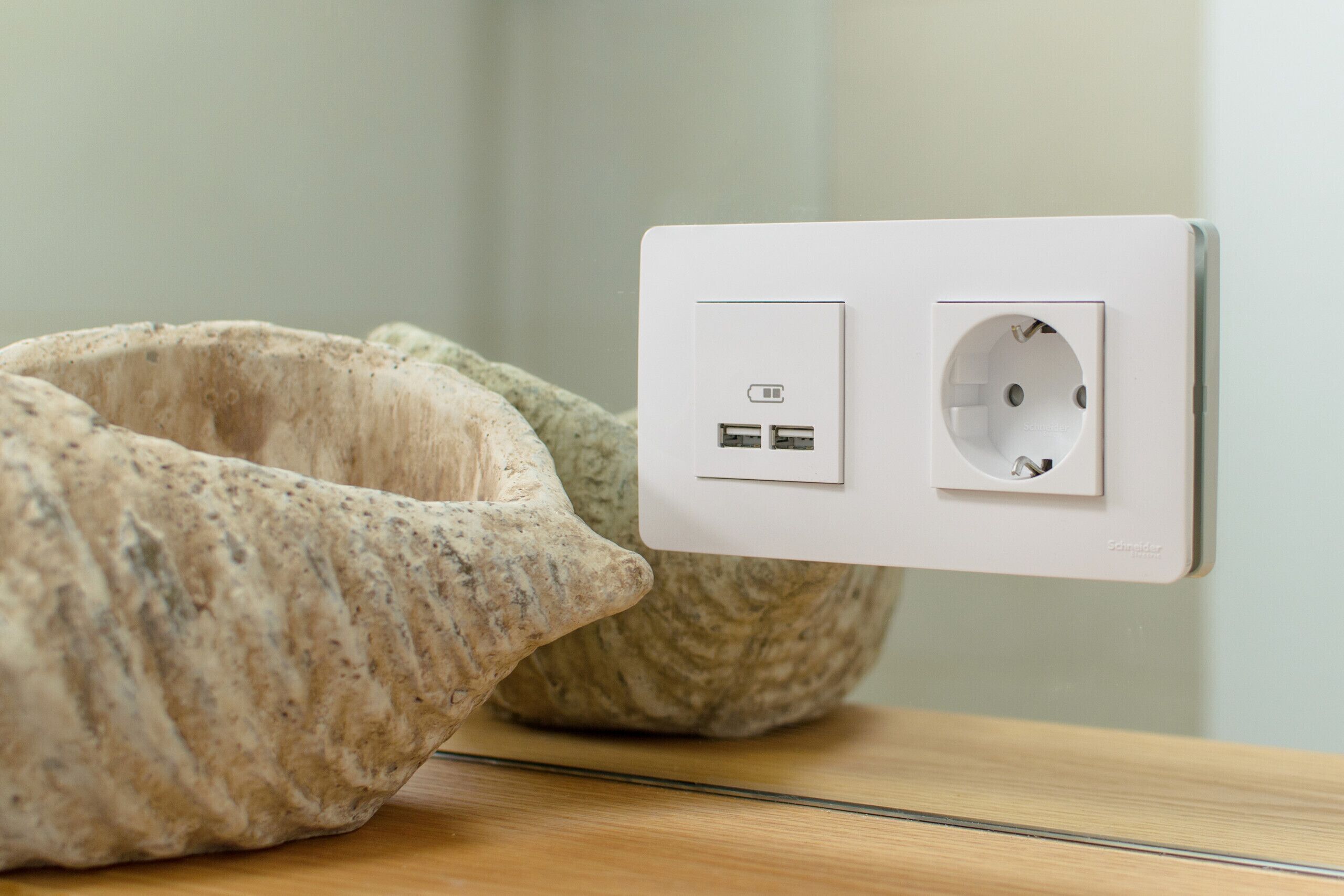 A wall-mounted power outlet with two USB ports and a standard electrical outlet.