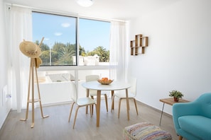 Relax in this serene space with a clear view of the outdoors, a round table, and comfortable seating for four.