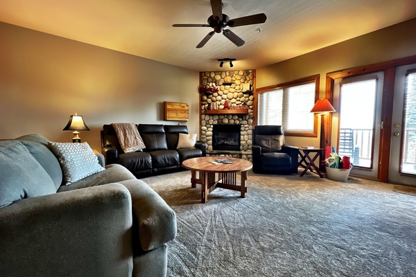 Spacious living room with gas fire place with door to deck and hot tub