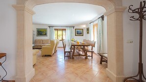 A spacious living area with a dining table, chairs, and a sofa.