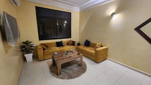 A living room with two sofas, a coffee table, and a large window. - Résidence Belle Vue 6  (Marrakech)
