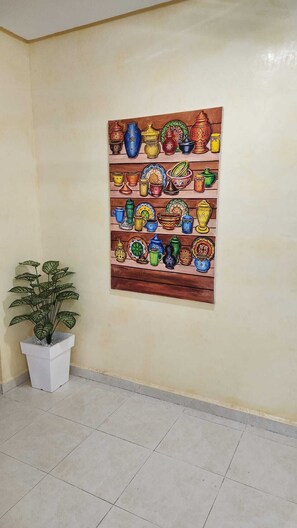 A wall with a colorful painting of various pottery items. - Résidence Belle Vue 6  (Marrakech)