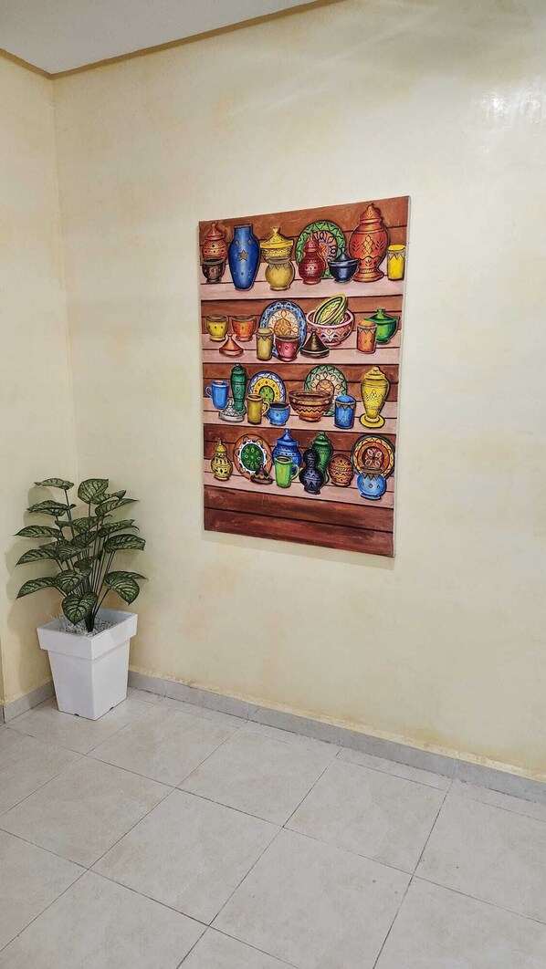 A wall with a colorful painting of various pottery items. - Résidence Belle Vue 6 (Marrakech)