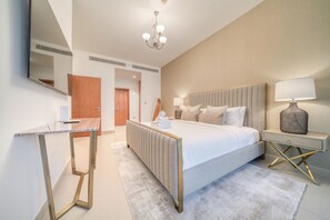Una habitación de hotel moderna con cama, mesita de noche, lámpara y espejo.
