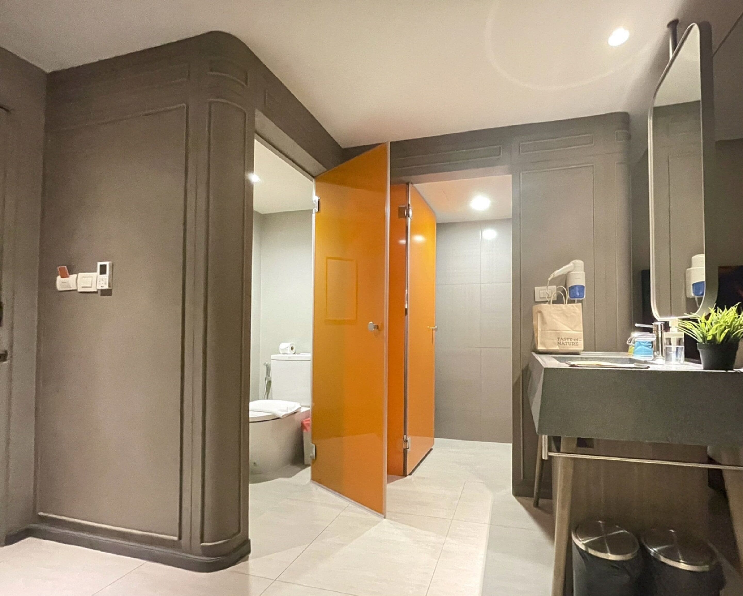 A modern bathroom with a toilet, sink, and mirror.
