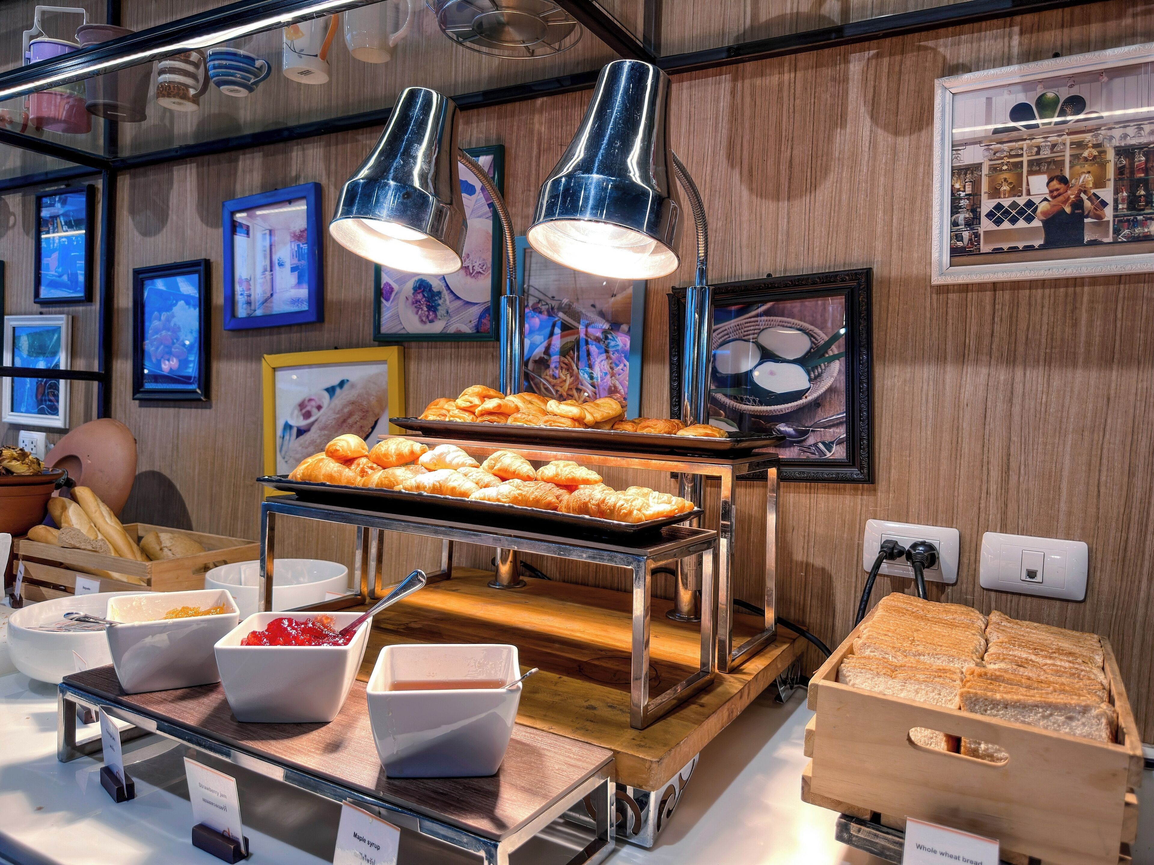 A breakfast buffet with pastries, bread, and syrups.