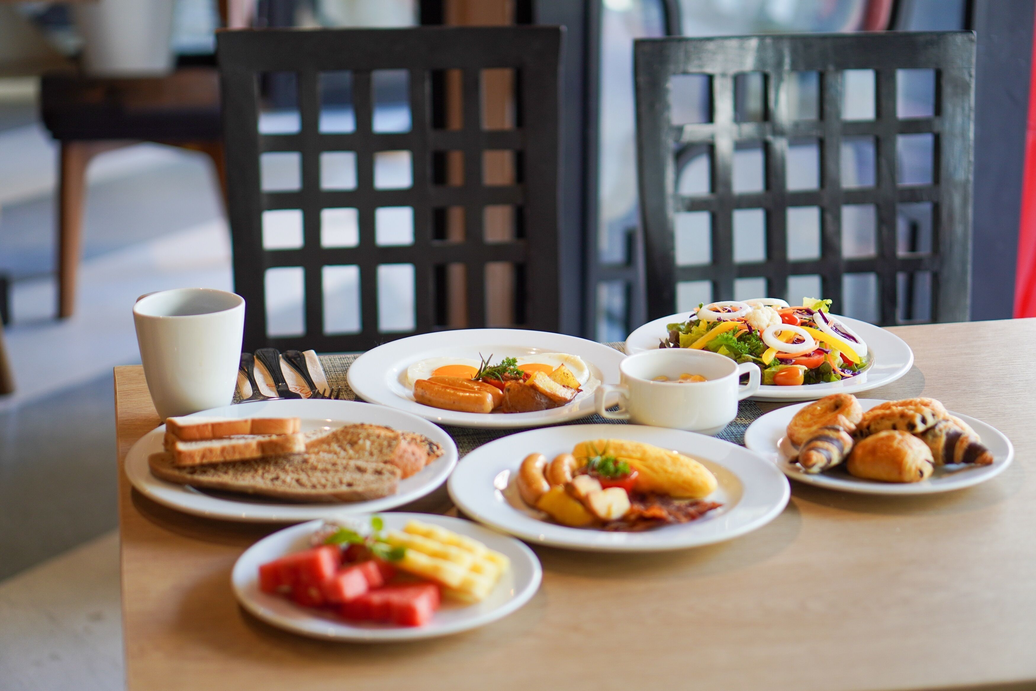 A breakfast table with various dishes including toast, eggs, and pastries.