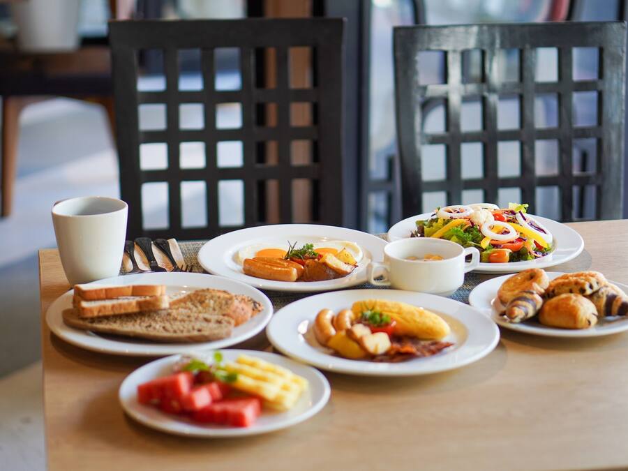 A breakfast table with various dishes including toast, eggs, and pastries.