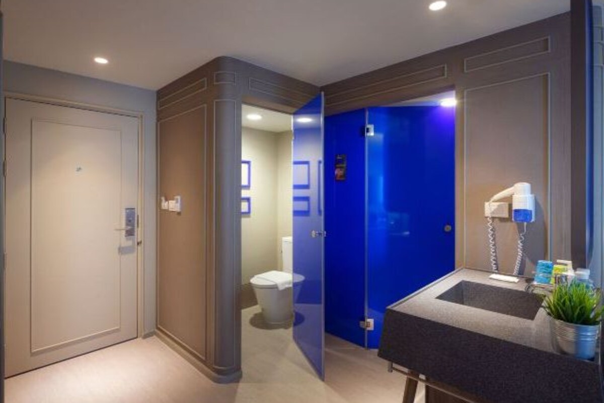Un baño moderno con lavamanos, espejo y artículos de aseo.