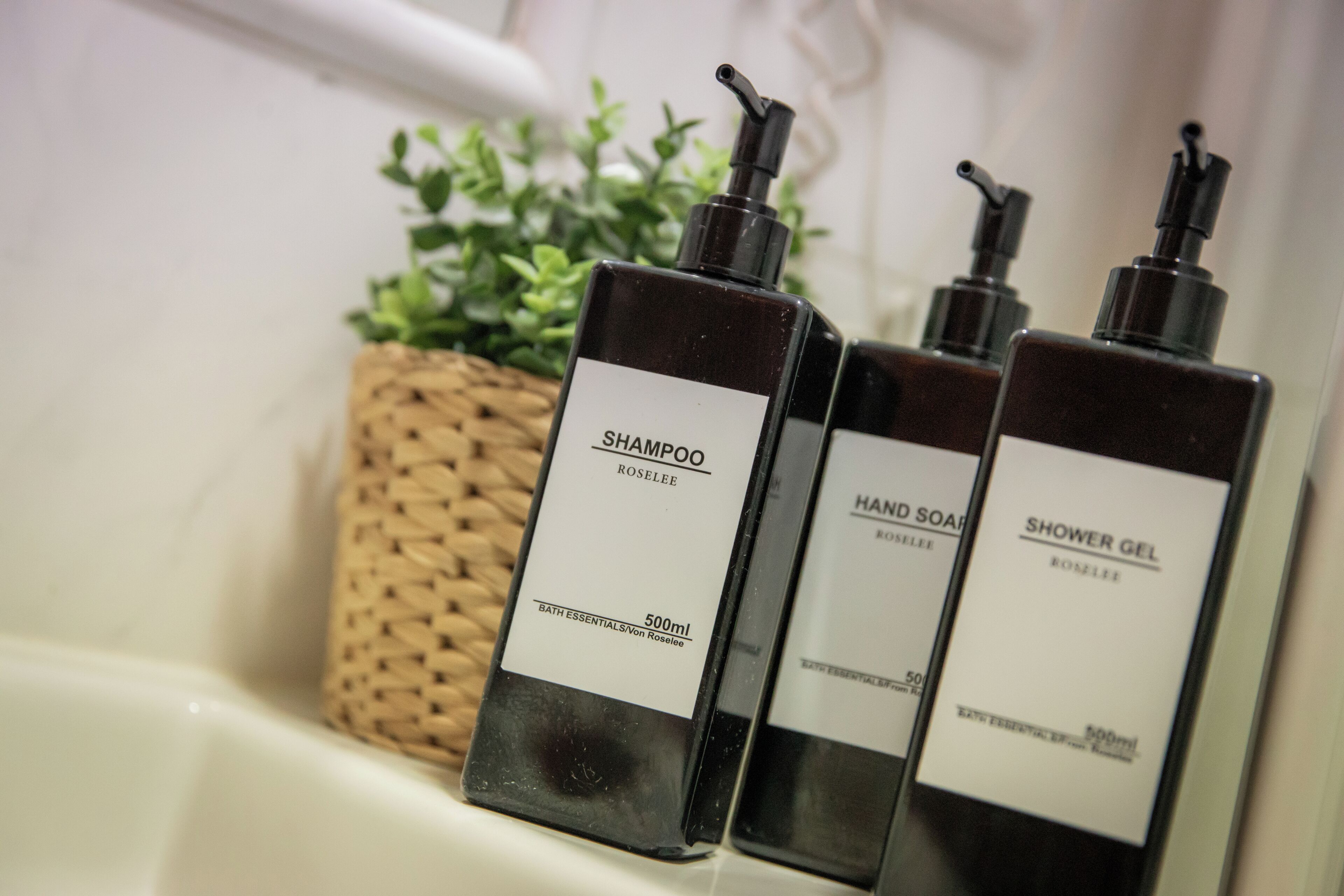 Tres botellas de artículos de baño sobre una encimera.