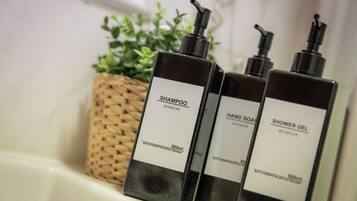 Tres botellas de artículos de baño sobre una encimera.