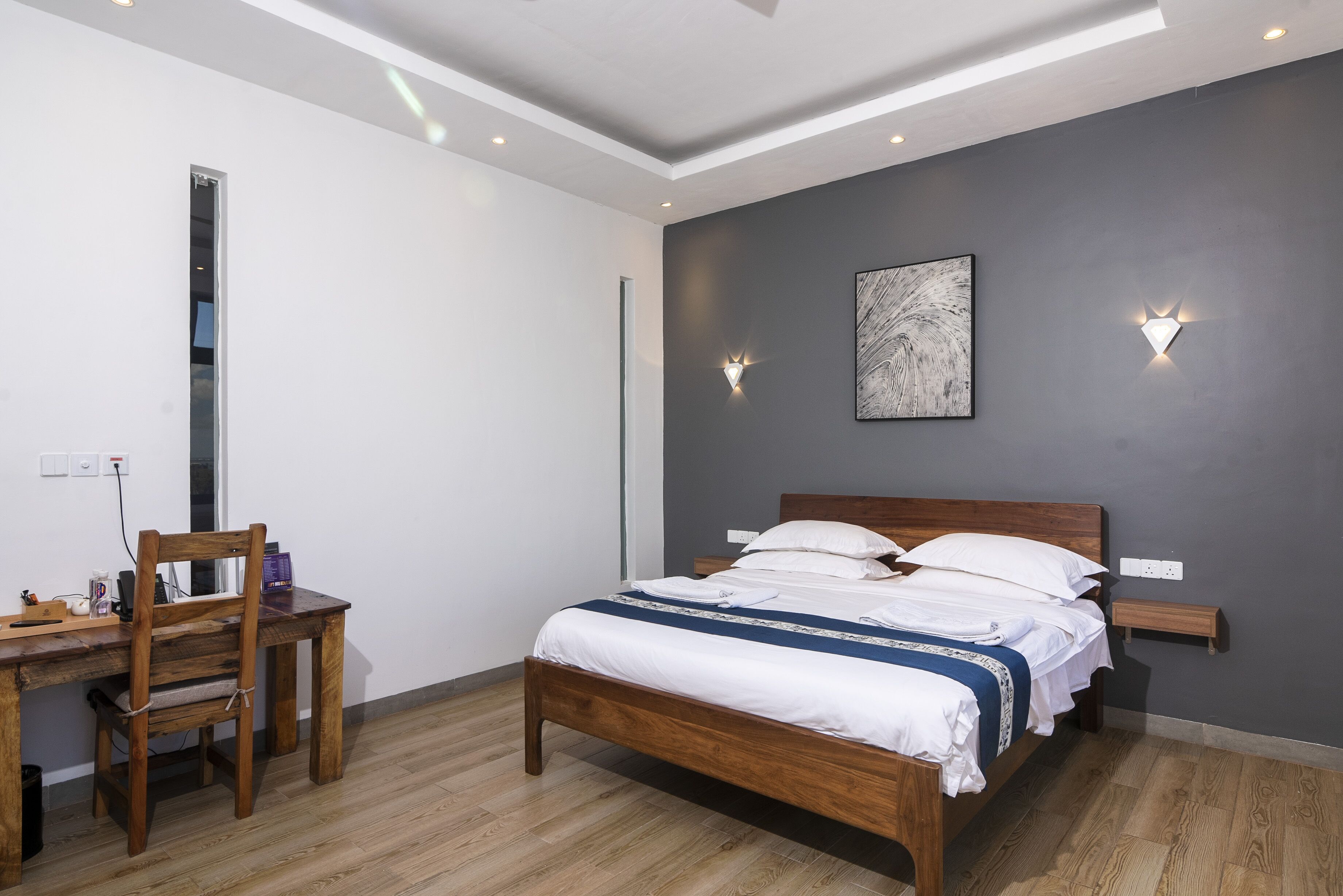 A bedroom with a wooden bed, a desk, and a chair.
