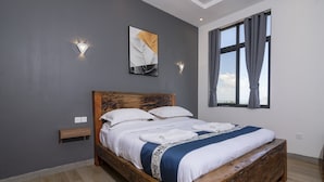 Een slaapkamer met een houten bed, grijze wanden en een raam met gordijnen.