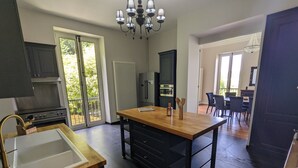 A modern kitchen with a central island, a built-in oven, and a large window.