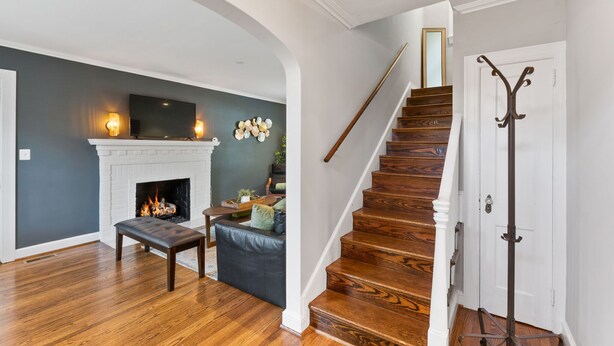 Un escalier avec des marches en bois et une porte blanche avec un porte-manteau.