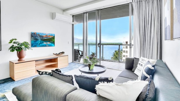 A modern living room with a sofa, coffee table, and artwork on the wall. - 901 Harbour Lights- Luxury 2BR Waterfront Apartment | Stunning Marina Views | Pool + Sauna (Cairns City)