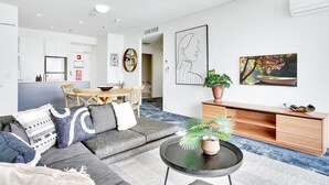 A modern living room with a sofa, coffee table, and artwork on the walls. - 901 Harbour Lights- Luxury 2BR Waterfront Apartment | Stunning Marina Views | Pool + Sauna (Cairns City)