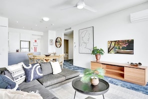 A modern living room with a sofa, coffee table, and artwork on the walls.