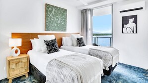 A hotel room with two beds, a ceiling fan, a window with a view, and artwork on the walls. - 901 Harbour Lights- Luxury 2BR Waterfront Apartment | Stunning Marina Views | Pool + Sauna (Cairns City)