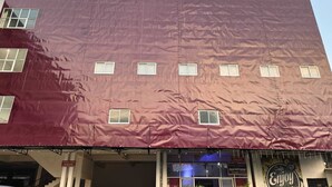 Ein Gebäude mit roter Fassade, zahlreichen Fenstern und einem Schild mit der Aufschrift 'Enjoy Life Music'.