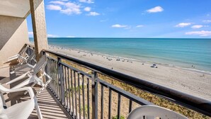 A balcony with a view of a beach. - Stunning Views 2BR Oceanfront, Beach Cove & Pools (North Myrtle Beach)