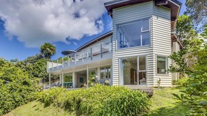 A modern two-story house with large windows, a balcony, and a well-maintained garden. - Absolute Beachfront - Oneroa Bay (Auckland)