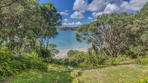 A coastal landscape with dense greenery and a clear view of the sea. - Absolute Beachfront - Oneroa Bay (Auckland)
